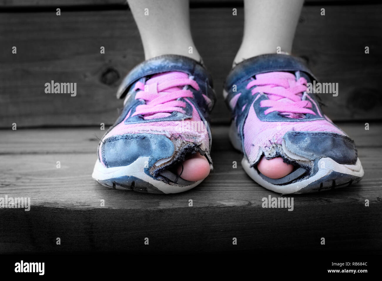 Desgastados zapatos con agujeros en los dedos utilizados por Homeless Child Fotografía stock - Alamy