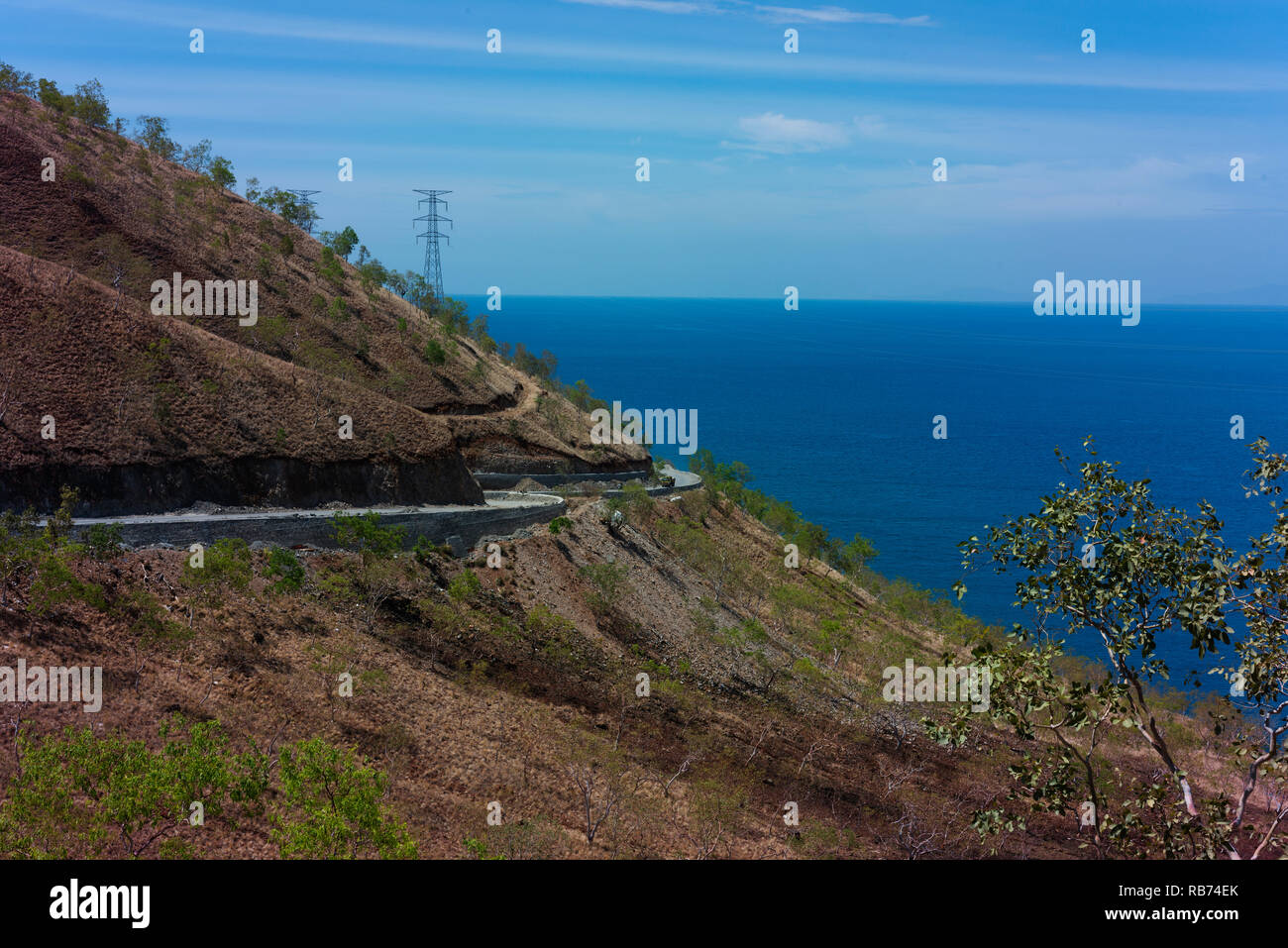 Una carretera recién construida en la costa norte de Timor Leste en el final de la estación seca. Foto de stock