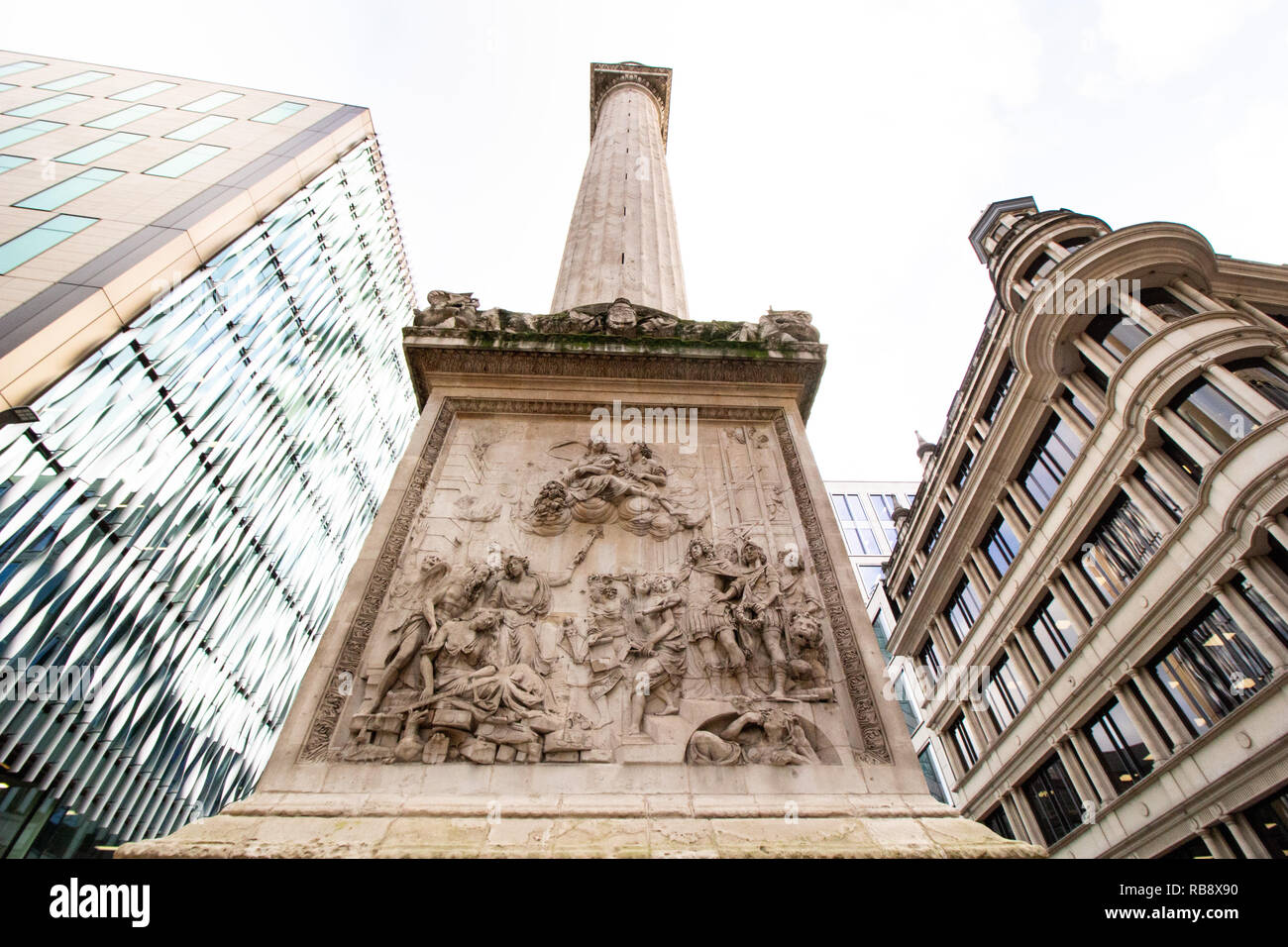 El alivio Cibber en la base del monumento al Gran Incendio de Londres, más conocido simplemente como el monumento es una columna de estilo dórico en Londres. Foto de stock