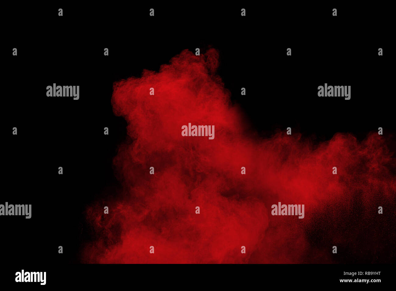 Explosión de polvo de color rojo sobre fondo negro.congelar el movimiento de partículas de polvo rojo de salpicaduras. Foto de stock