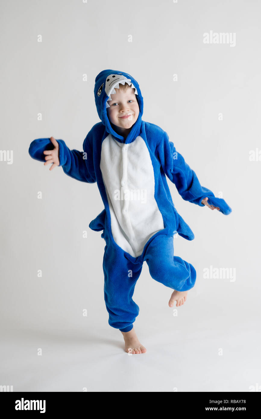 Niñito alegre posando sobre fondo blanco en kigurumi, tiburón azul traje Fotografía de stock - Alamy