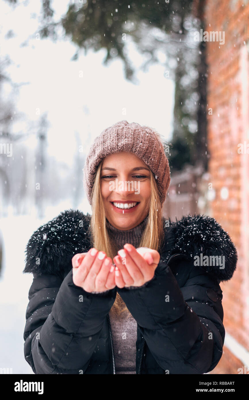 Mujer con sonrisa hermosa disfrutando de la nieve. Foto de stock