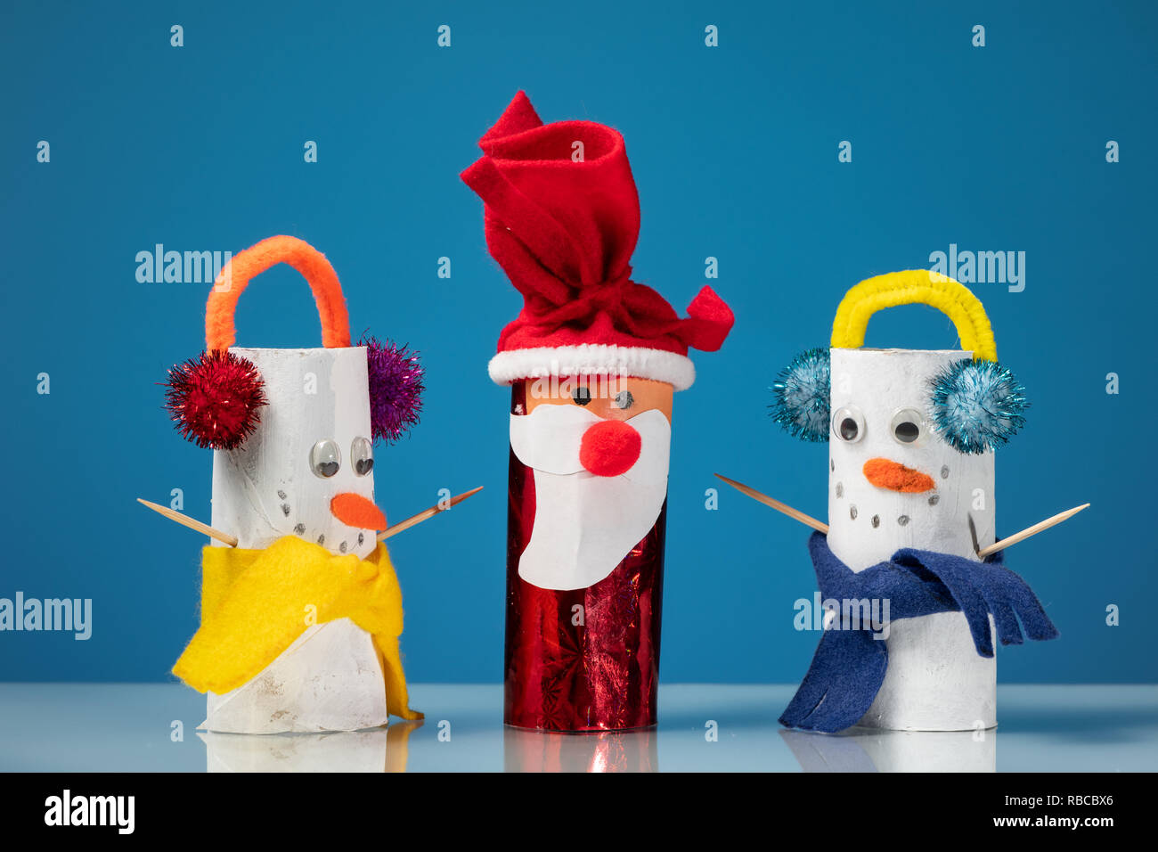 Figuras de dos muñecos de nieve y Santa Claus de rollos de papel higiénico  por un niño, fondo azul Fotografía de stock - Alamy