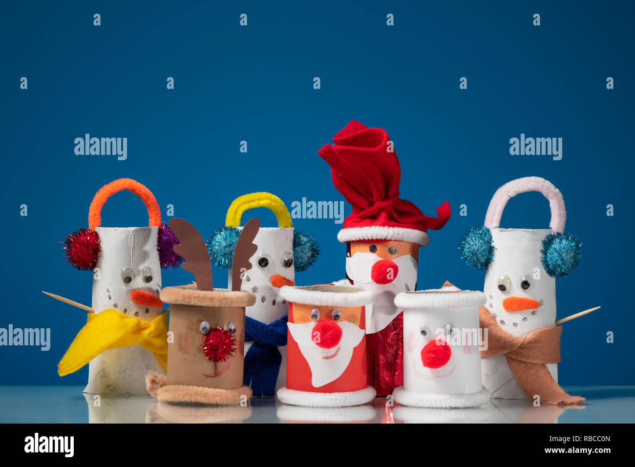 Varias figuras de Santa Claus, muñecos de nieve y renos de rollos de papel  higiénico por un niño, fondo azul Fotografía de stock - Alamy