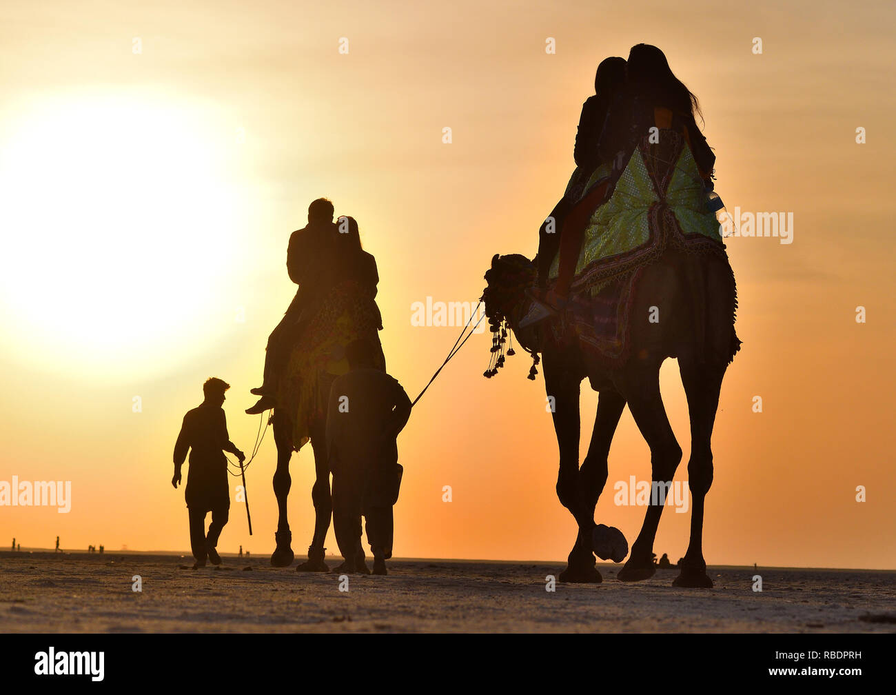 Los visitantes viajaban en camello en blanco Rann Rann de Kutch en mayor, Gujarat, India Foto de stock