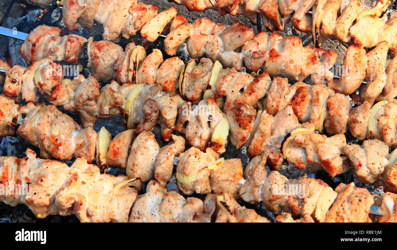 Apetitoso closeup pinchito. Carne de cerdo cocinada. Almuerzo barbacoa al aire libre. Trozos de carne de cerdo a la parrilla. Pinchito preparada en la barbacoa de obra Foto de stock