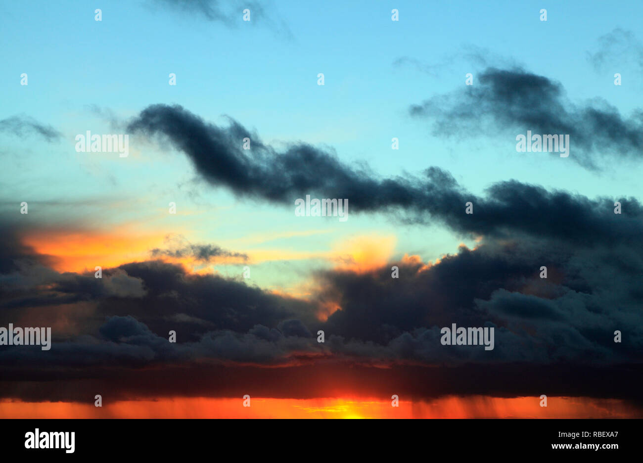 Puesta de sol, rojo, azul, rosa, cielo, nubes negras, tormenta, clima, cielo, cielo, formación, formaciones, luz del atardecer, Norfolk, Inglaterra, Reino Unido. Foto de stock