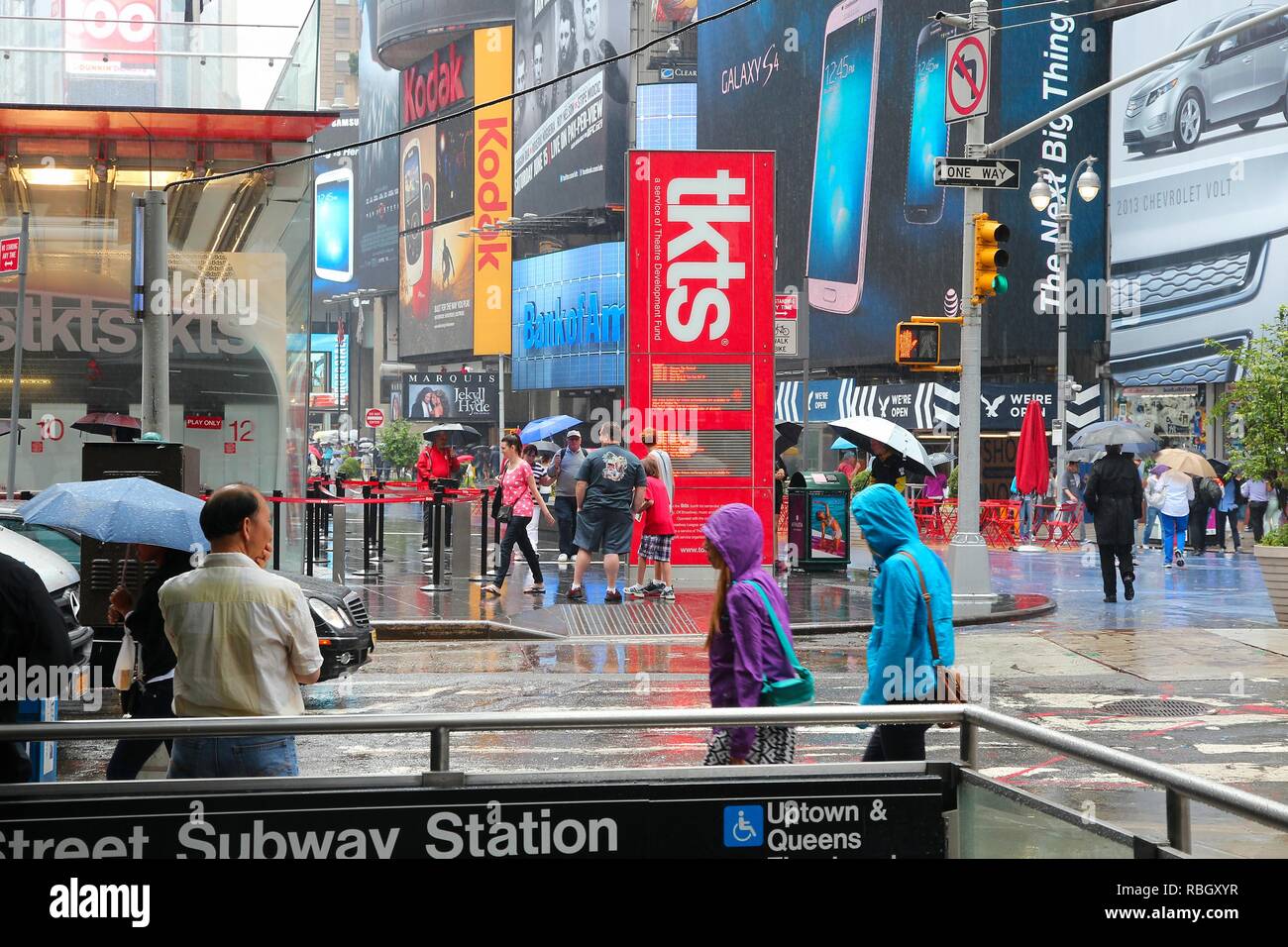 Nueva York, Estados Unidos - Junio 10, 2013: la gente camina en la lluvia de Times Square, en Nueva York Times Square es uno de los lugares más reconocidos en el mundo. Más de 300.000 Foto de stock