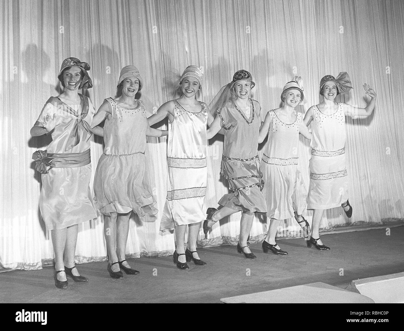 1920 remake. Un grupo de mujeres en un teatro están planteando en el  escenario típico de los años 1920 vestidos y sombreros. Están bailando la  danza típica de 1920 Charleston. Suecia Foto