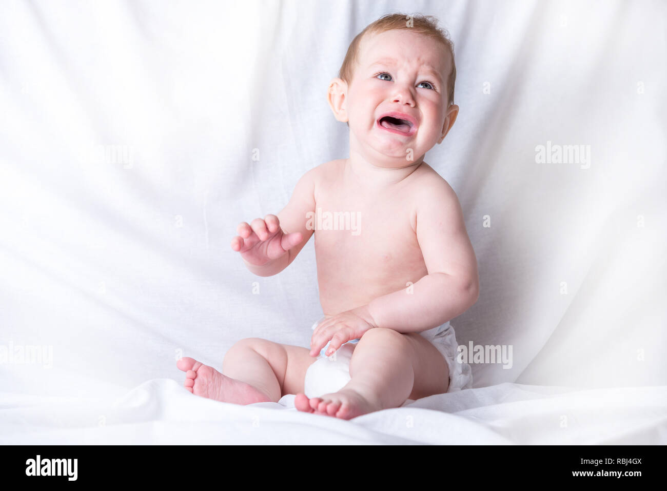 Cute Blue Eyed Bebe 6 9 Meses Triste Llorando Fondo Blanco Las Emociones De Los Ninos El Dolor Del Proceso De Denticion Fotografia De Stock Alamy