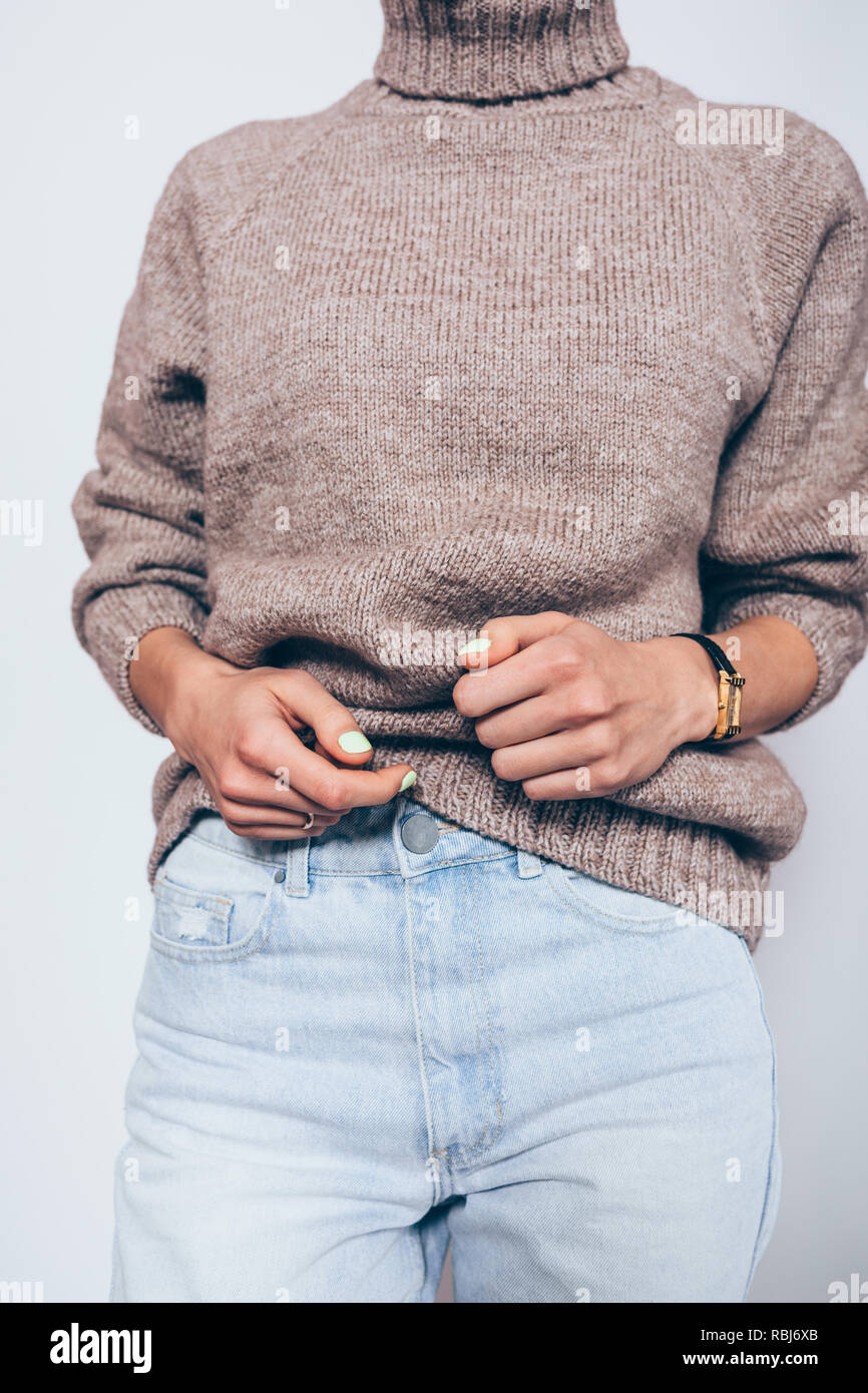 Elegante elegante ropa para clima frío. Joven mujer vistiendo  sobredimensionado suéter cuello tortuga marrón y azul novio jeans  Fotografía de stock - Alamy