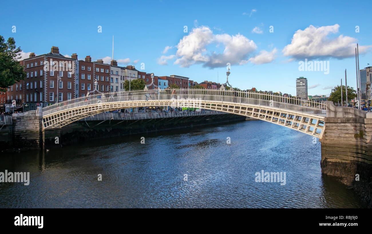 La gente camina sobre el Ha'Penny Bridge sobre el río Liffey en Dublín, Irlanda. Foto de stock