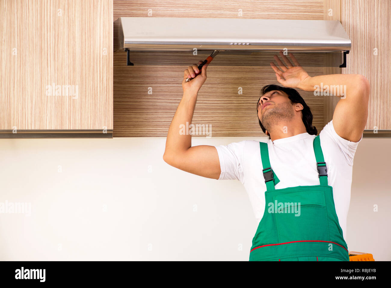 Contratista joven reparación del aire acondicionado en la cocina Fotografía  de stock - Alamy