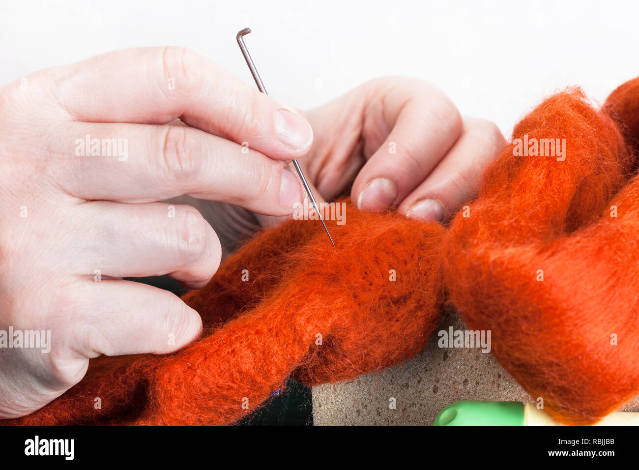 Master Class de reparación utilizando guantes de lana aguja fieltrado de proceso - artesano remozando felted paño fieltrado con aguja Foto de stock