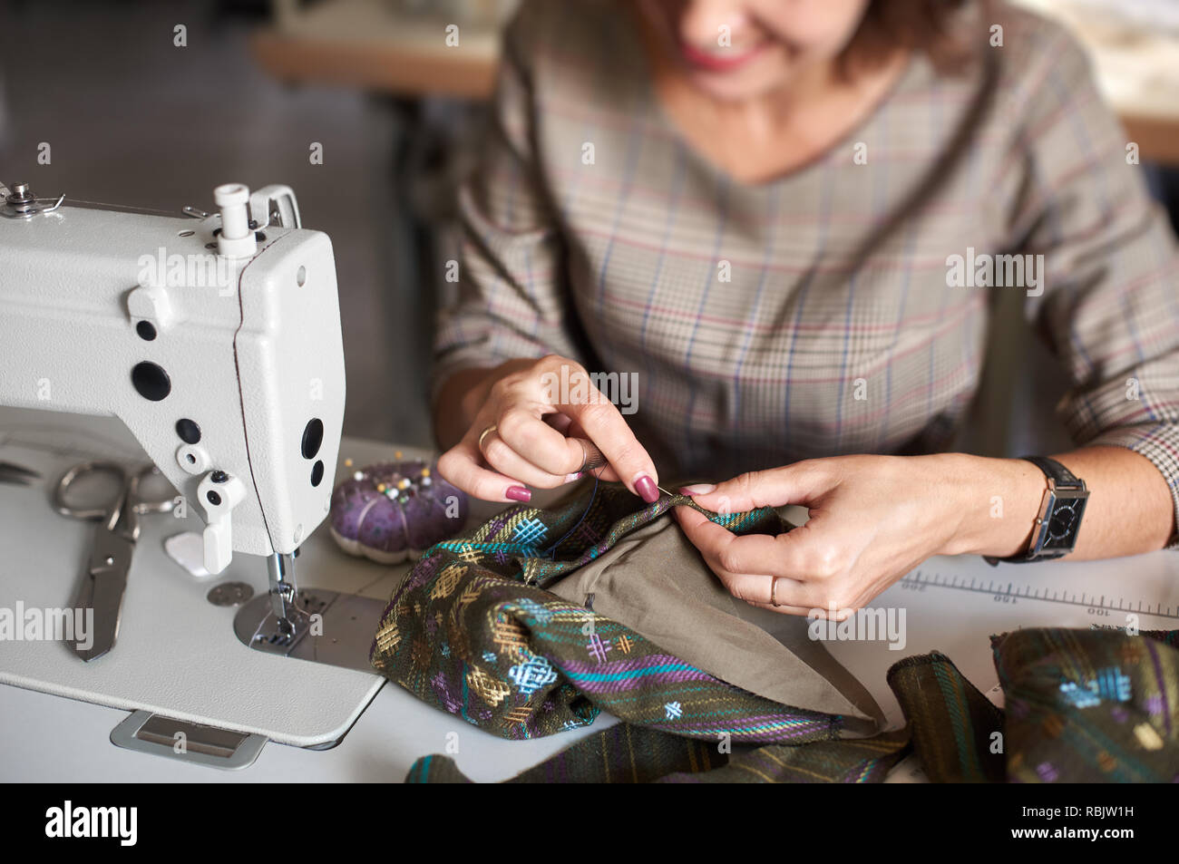 Adaptar workplace: vista desde arriba de la máquina de coser eléctrica y  cierre de mujer manos con aguja coser ropa antes de sewin detalles  Fotografía de stock - Alamy