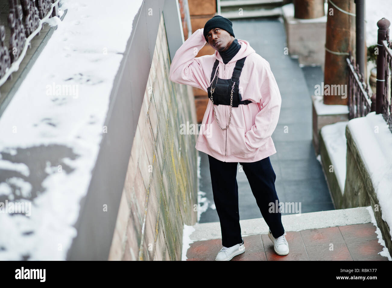 Elegante estilo urbano hombre afroamericano en rosa hoodie planteados en  día de invierno Fotografía de stock - Alamy