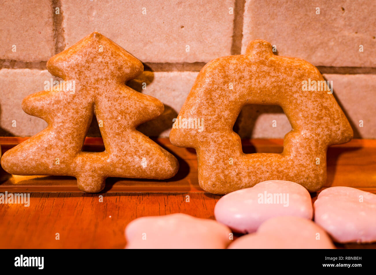 Navidad gingerbreads formado como un árbol de Navidad y una casa con poco pink cookies en la encimera de la cocina Foto de stock