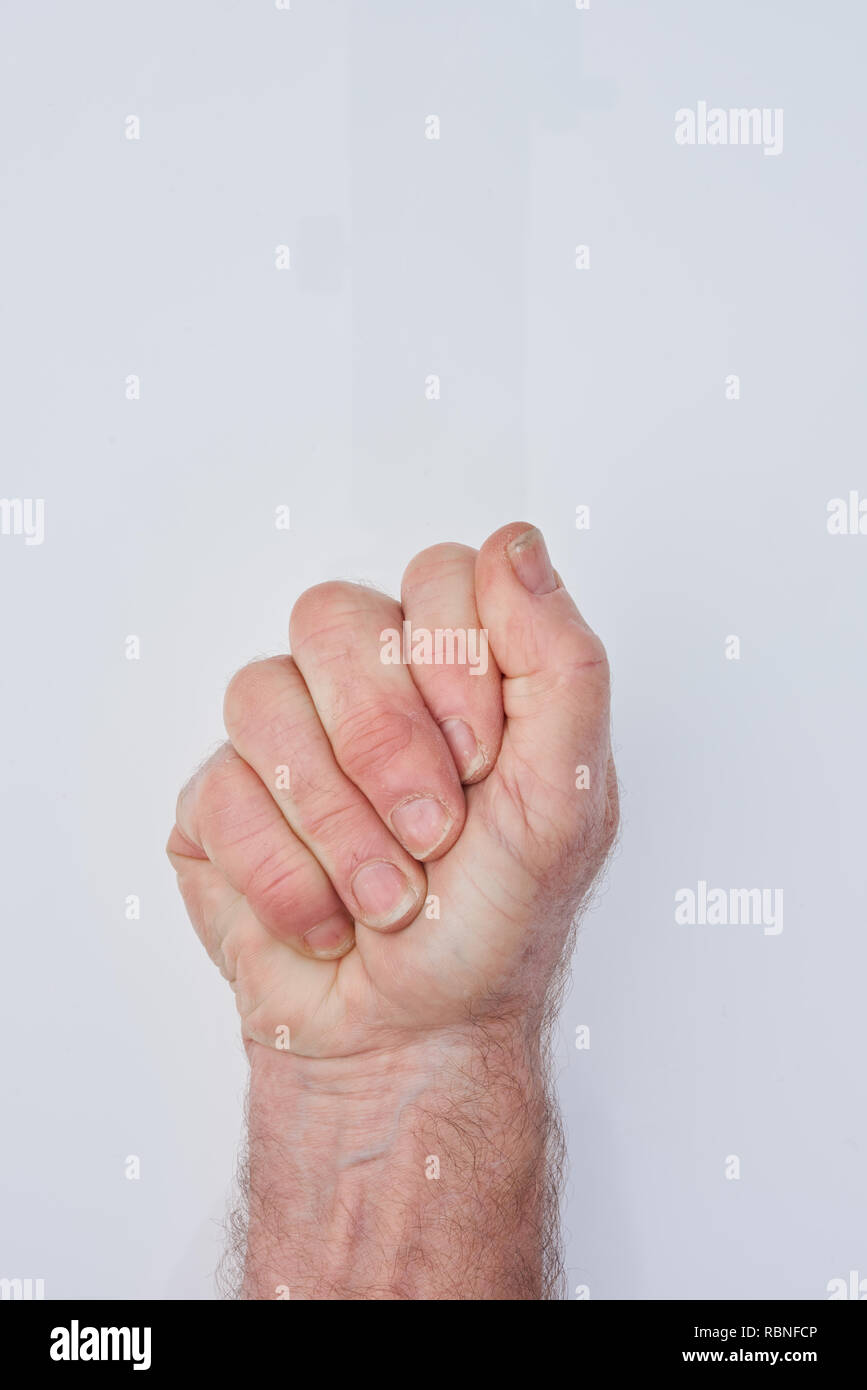 Una mano de un hombre viejo apretadamente agarra algo oculto en la palma de su mano Foto de stock