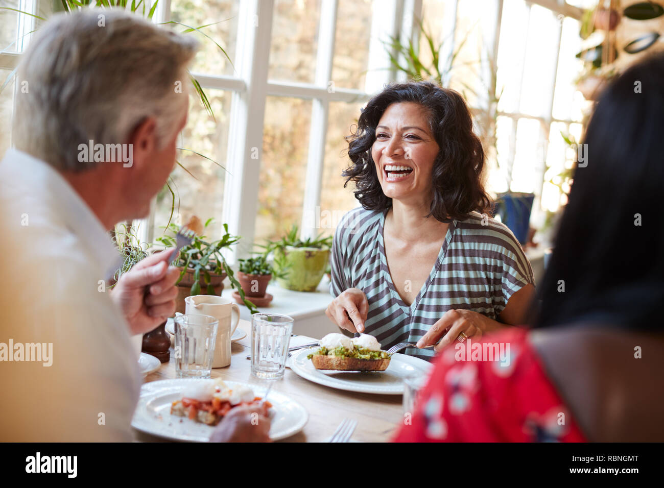 Laughing mujer riendo con amigo masculino en un café, cerrar Foto de stock