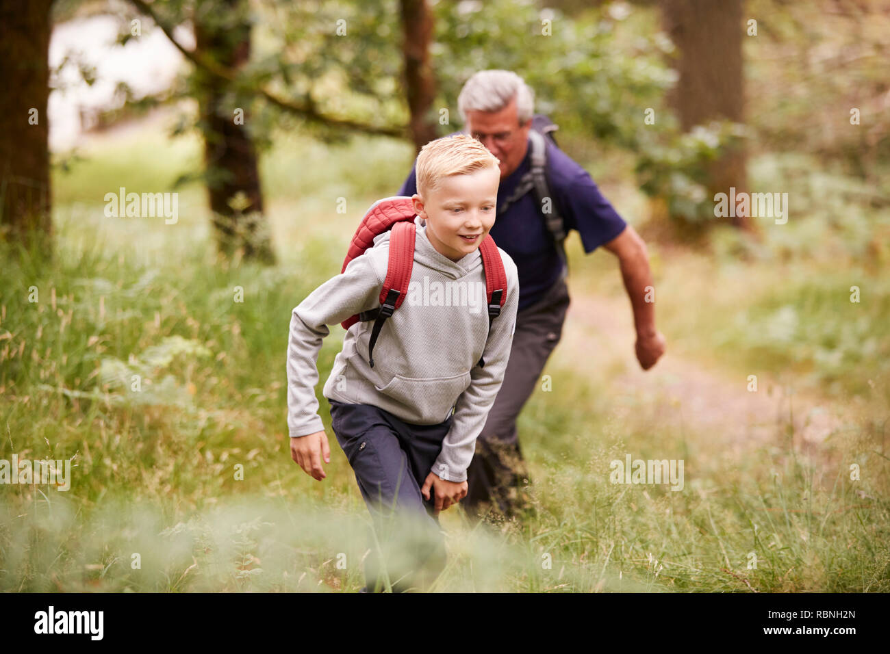 Cierre de pre-teen boy senderismo con su abuelo en un bosque, el enfoque selectivo Foto de stock