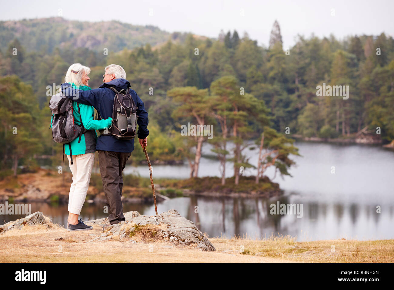 Senior pareja abrazada y admirar una vista de los lagos mirarse, vista posterior Foto de stock