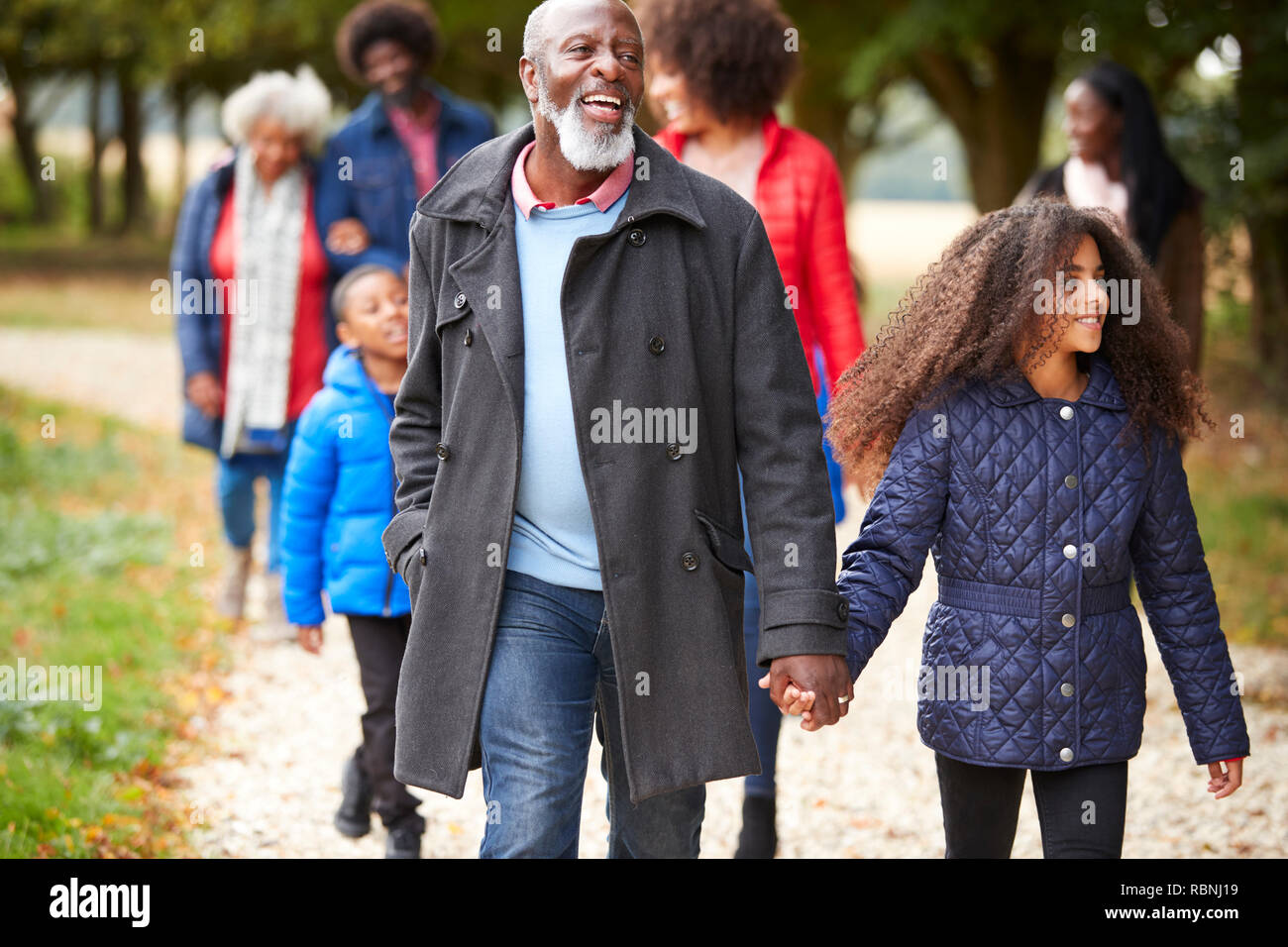 Familia de generación múltiple en otoño de caminar juntos en el campo Foto de stock