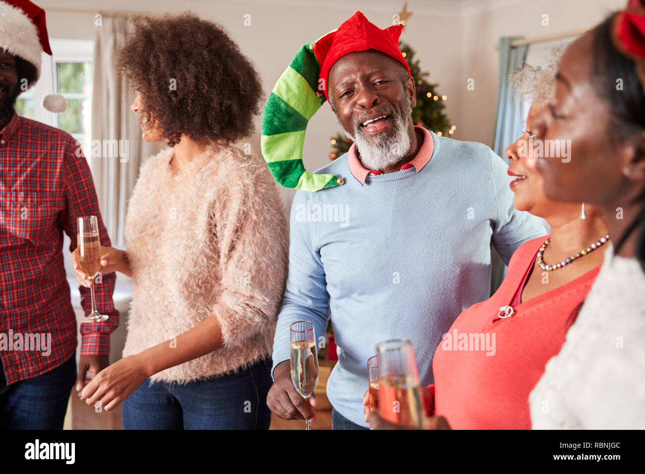 Los padres con hijos adultos beber champán, que celebran la Navidad en el hogar Foto de stock