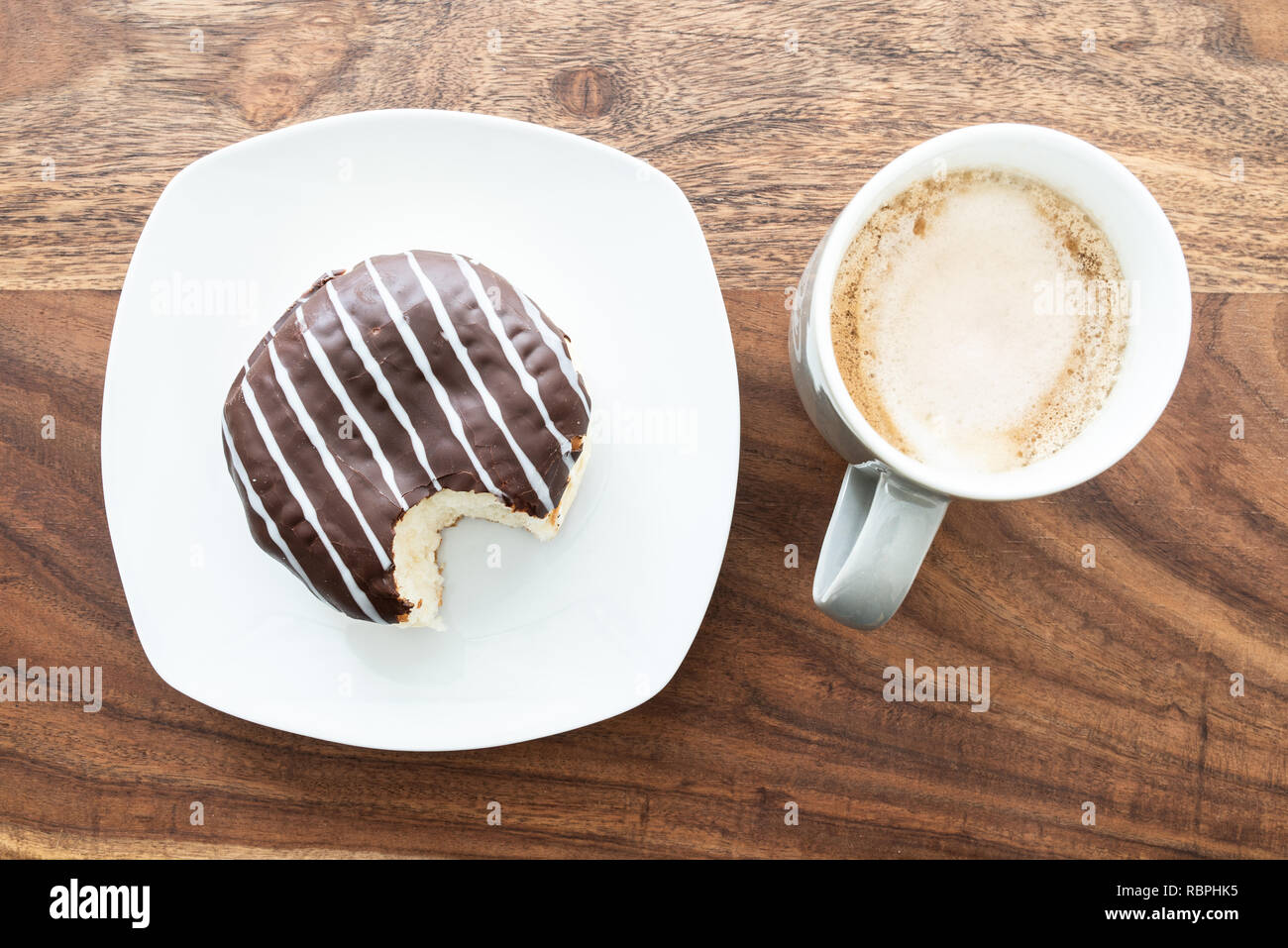 Recubierto de chocolate jelly donut sobre mesa de madera Foto de stock