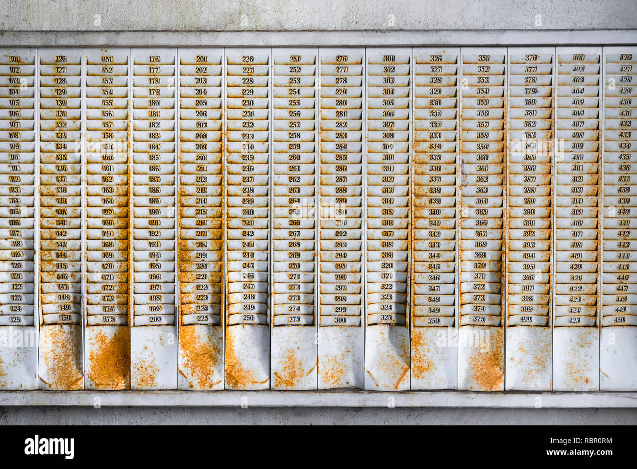 Montaje en pared oxidado con ranuras para tarjetas sellos numerados en una fábrica abandonada la construcción Foto de stock