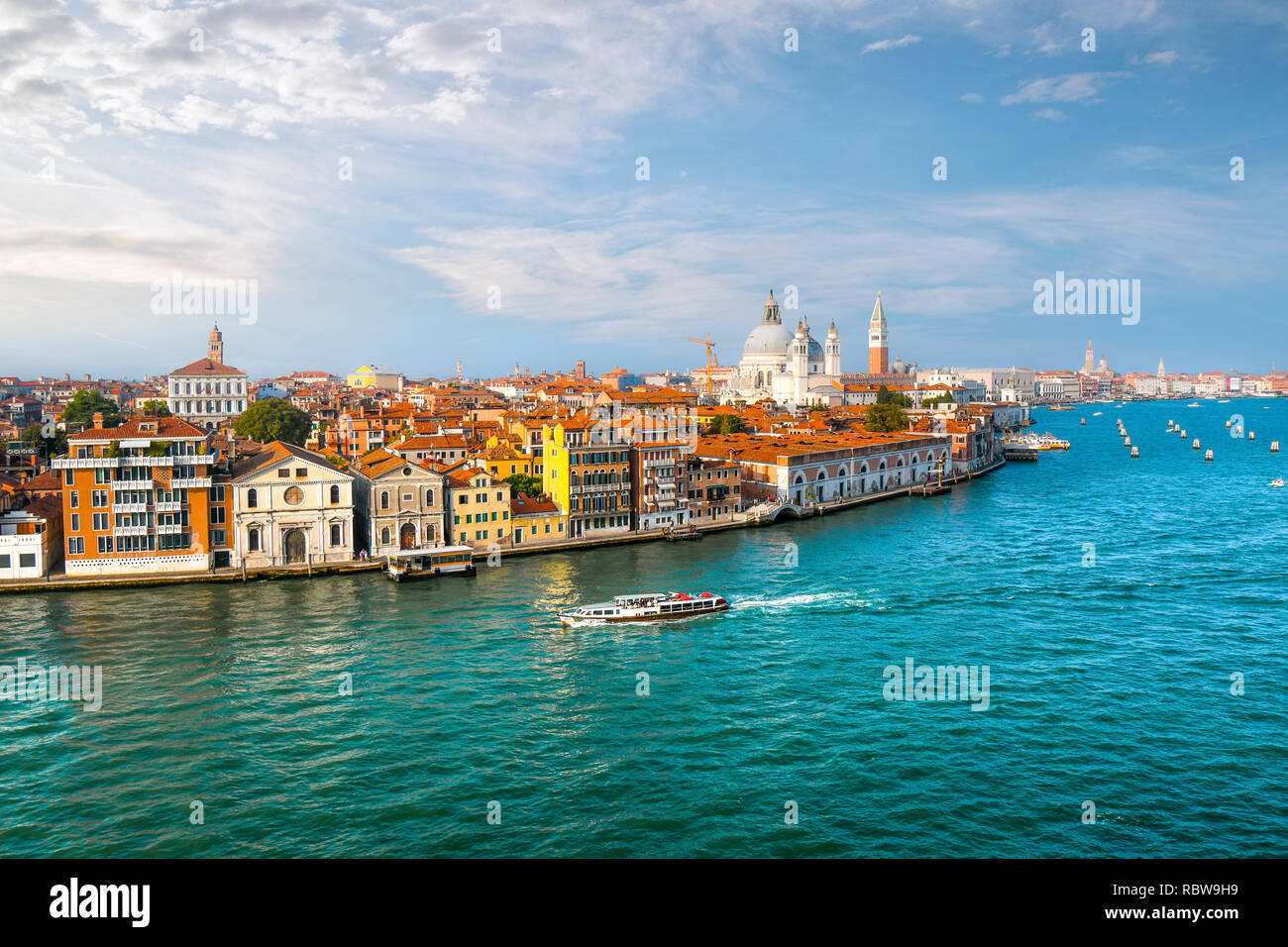 Un taxi acuático en Venecia, Italia cruceros del gran canal con la cúpula de Santa Maria della Salute, el campanario de la catedral y de la plaza de San Marcos en vista Foto de stock