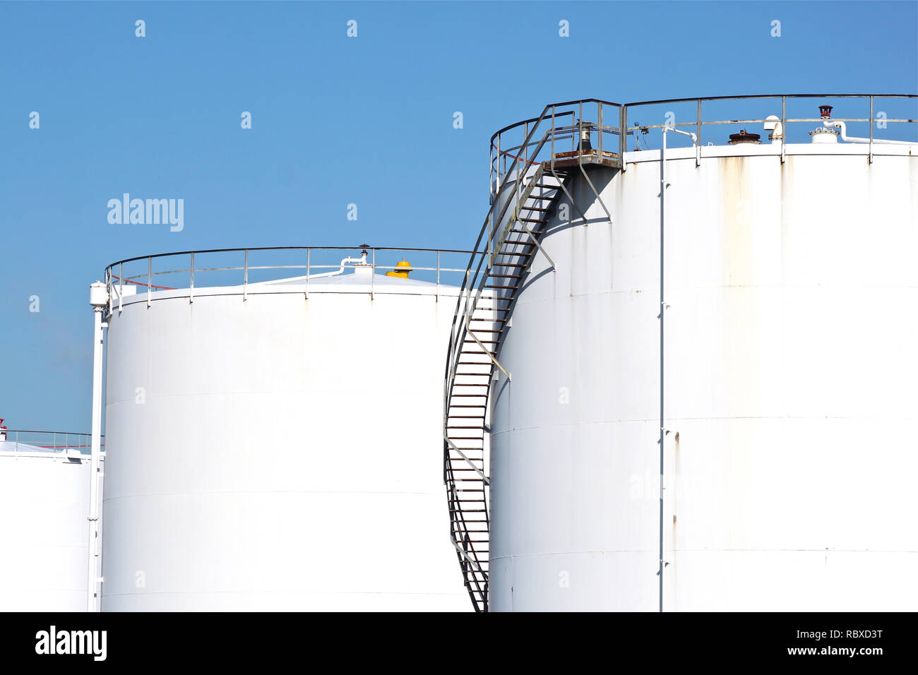 Blanco grandes tanques de almacenamiento de petróleo y combustible en una refinería. Foto de stock