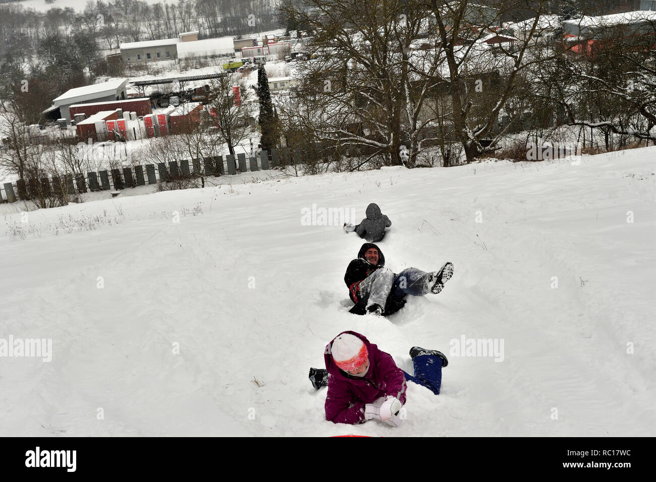 Los padres con niños para deslizarse sobre la nieve y disfrutar Foto de stock