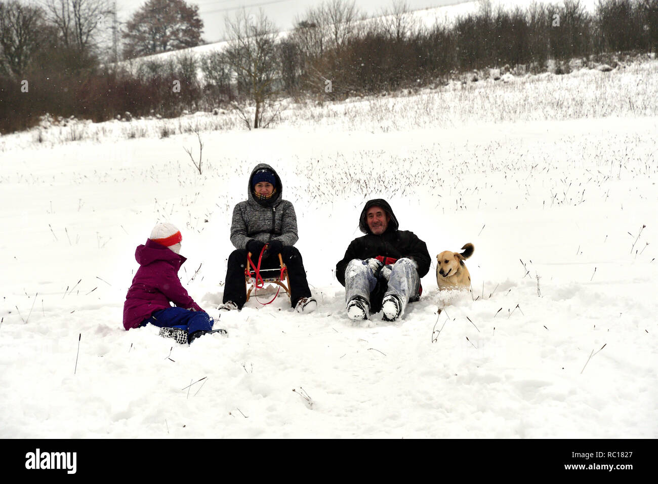 Los padres con niños para deslizarse sobre la nieve y disfrutar Foto de stock