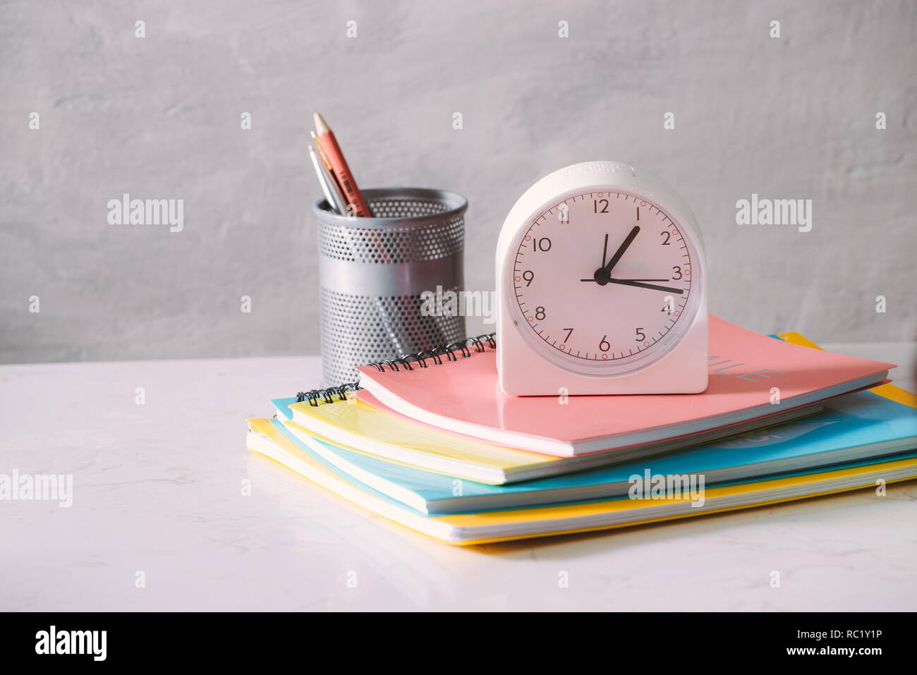 Vaso de café sobre la mesa con el libro y el reloj por la mañana Foto de stock