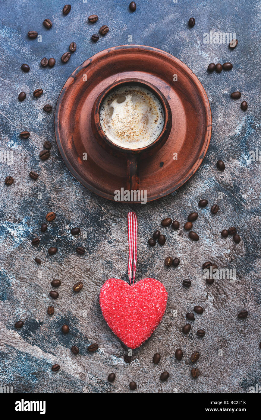 Café caliente y el corazón rojo sobre un fondo abstracto rústico. El concepto de celebración, el día de los enamorados. Vista desde arriba Foto de stock
