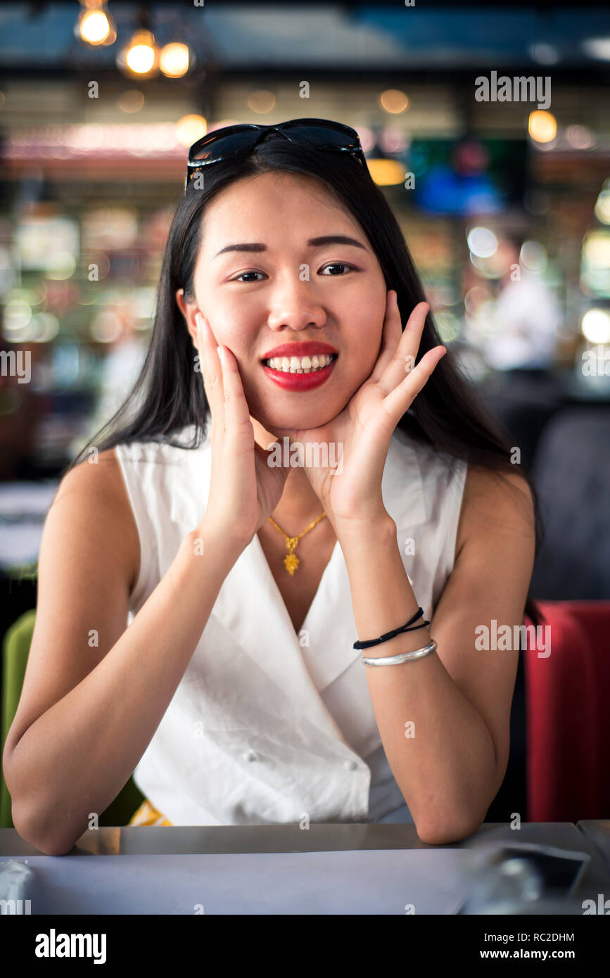 Alegre muchacha asiática en el restaurante vertical Foto de stock
