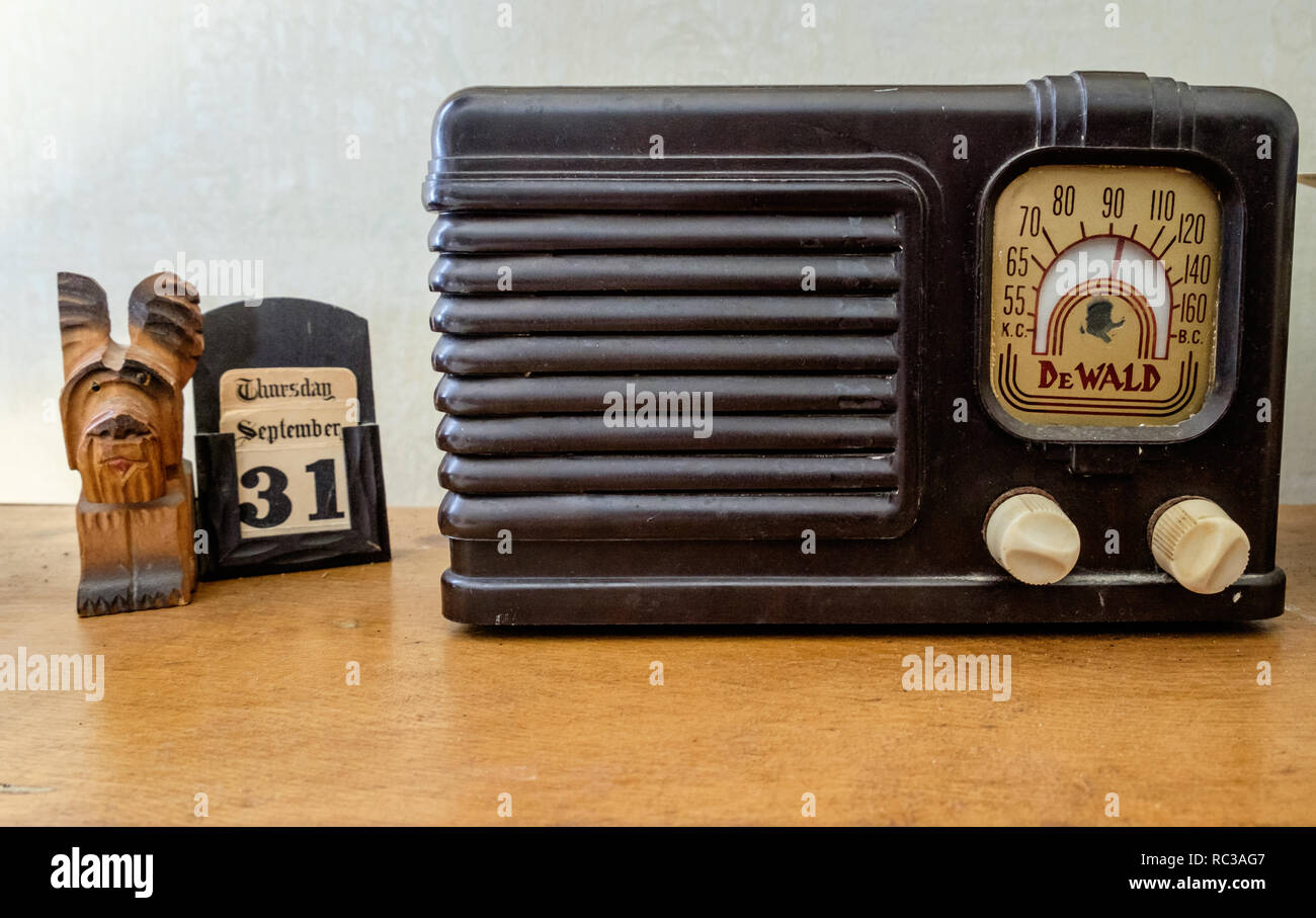 Vintage DeWald modelo A-514 Tabla Bantam Radio en el cuadro junto a Calendario y perro de madera tallada. Foto de stock