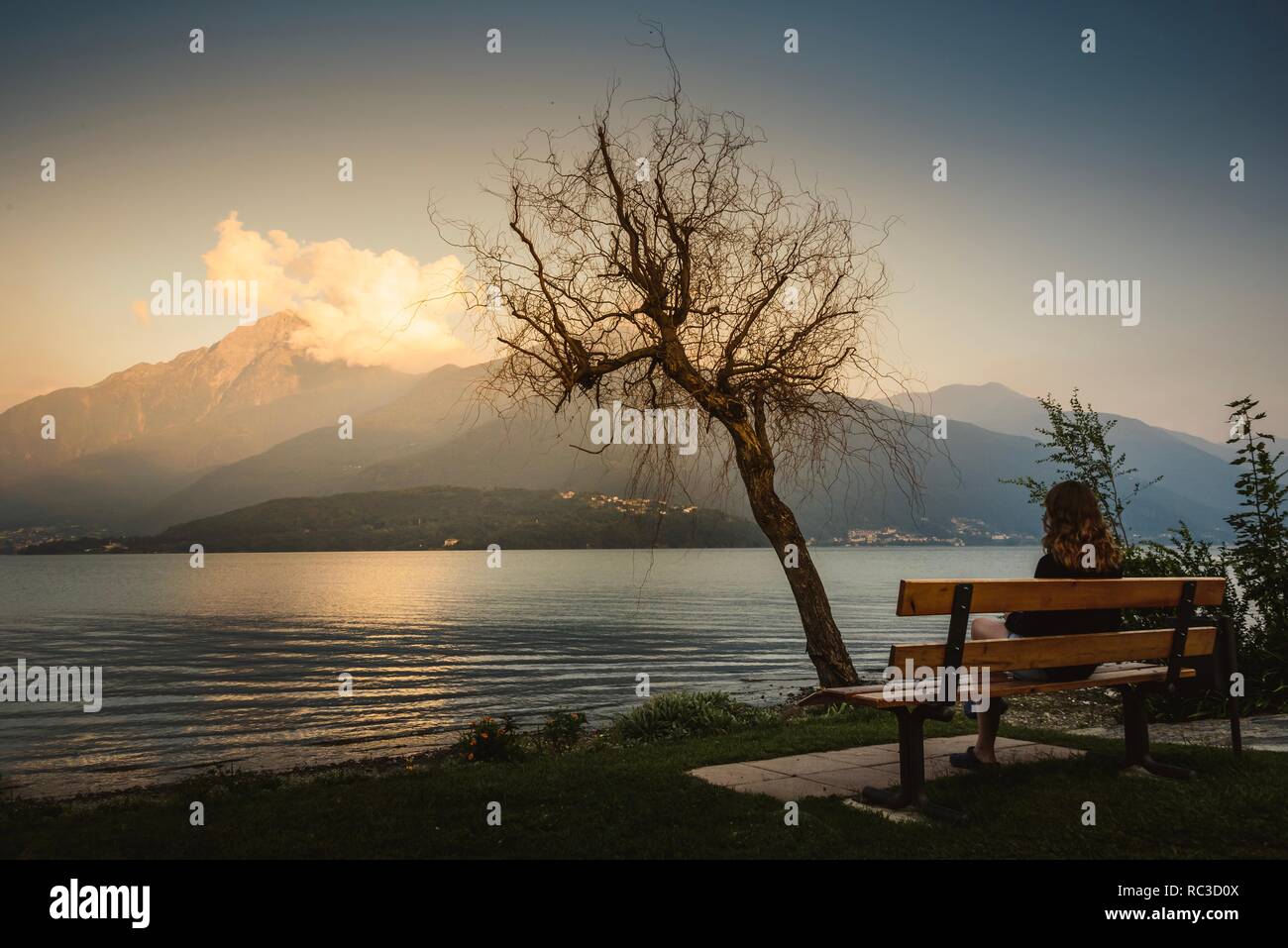 Mujer mirando el atardecer en el Lago de Como, Italia Foto de stock