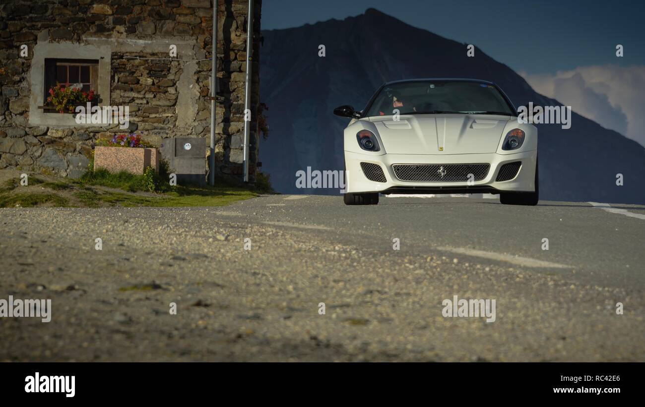 Ferrari blanco conduciendo a través de los Alpes, Italia Foto de stock