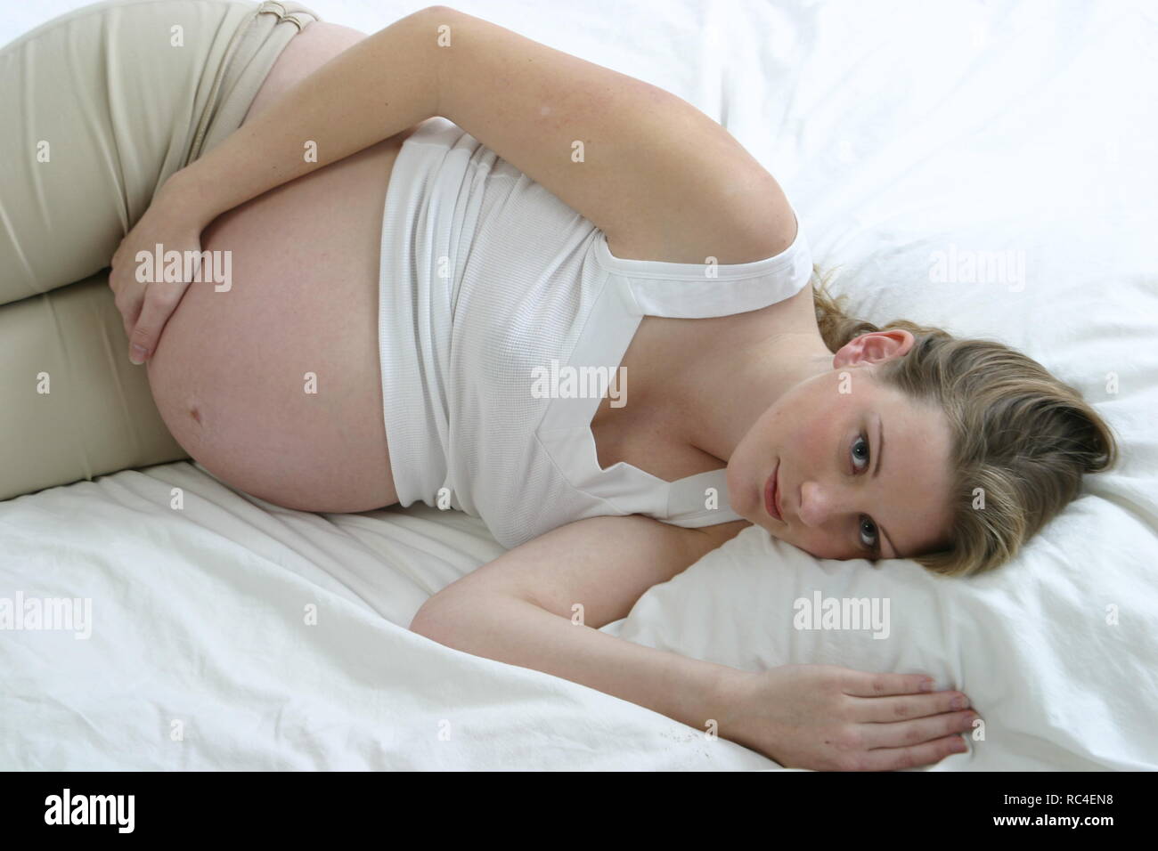Bastante más de 30 embarazadas mujer caucásica relajarse o descansar en la cama . Foto de stock