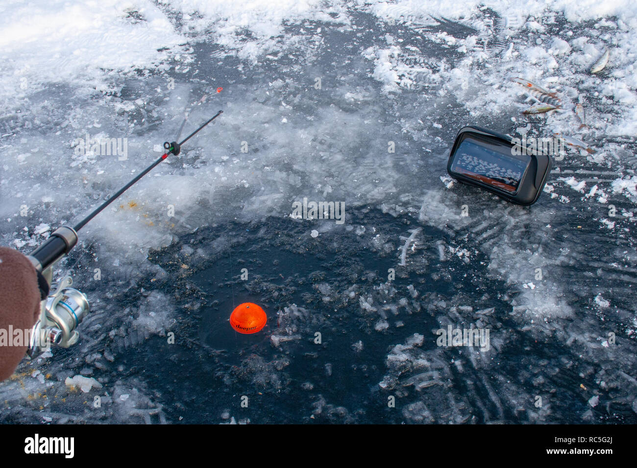 Pescar en un lago congelado en invierno con sonar en un agujero Fotografía  de stock - Alamy