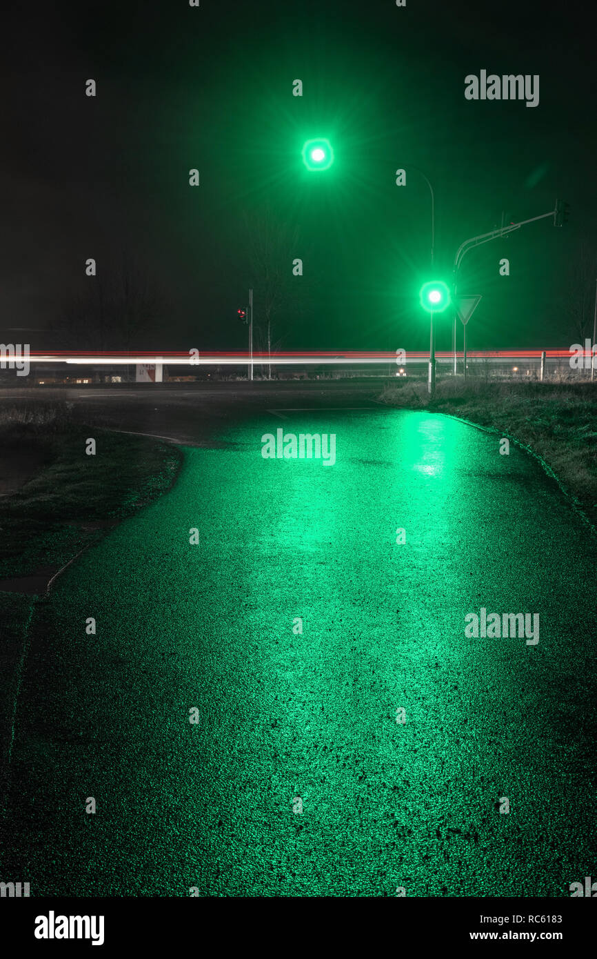 Semáforo mostrando luz verde en la noche húmeda. Foto de stock
