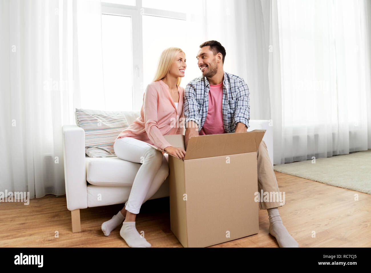 Feliz pareja con Abrir paquete en casa Fotografía de stock - Alamy