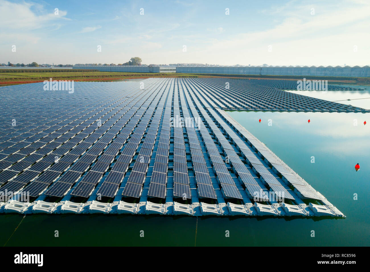 Paneles solares flotantes instalados en el abastecimiento de agua de los vecinos de los invernaderos, vista elevada, Países Bajos Foto de stock