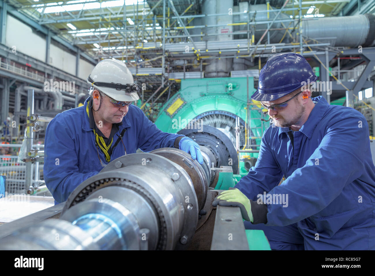 Ingenieros inspeccionar engranajes a finales del generador en la central de energía nuclear durante la parada Foto de stock