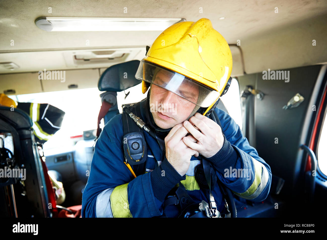 Bombero poniendo sobre el casco de bomberos Foto de stock