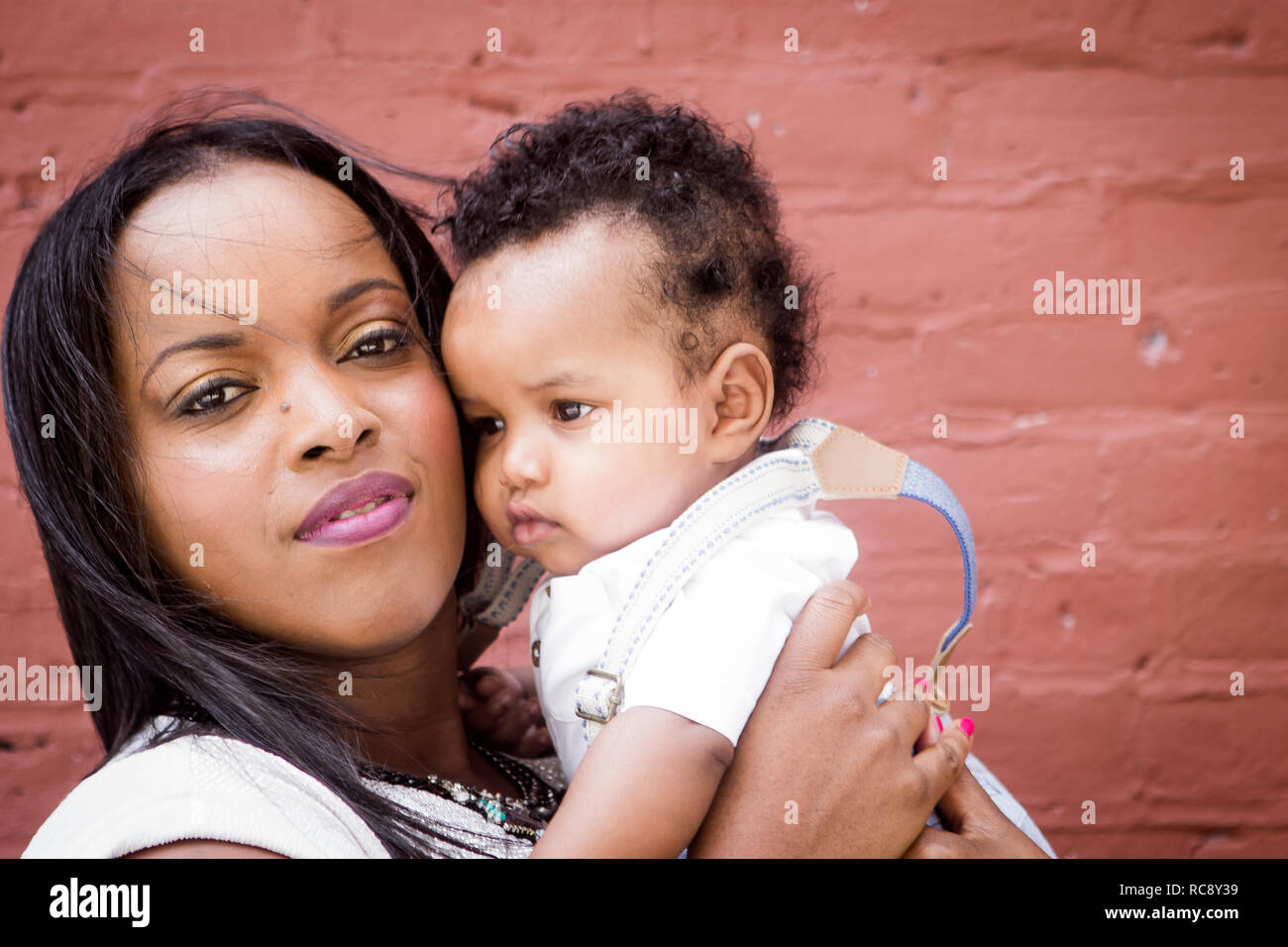 Cerrar negro de la madre y el bebé niña fuera besos Foto de stock