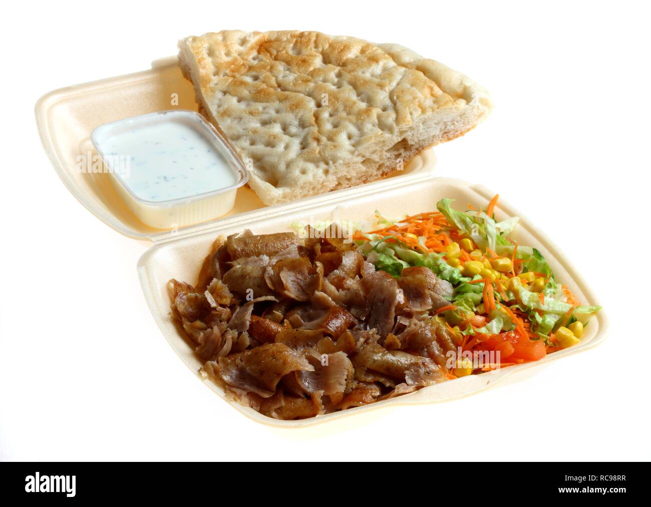 Fast food, placa de doner kebab, Döner con carne, ensalada, salsa de yogur de ajo y pan de pita en plástico de embalaje de comida para llevar Foto de stock