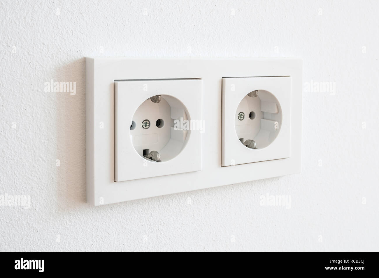 Tomas de electricidad enchufe universal blanco sobre una pared blanca  Fotografía de stock - Alamy