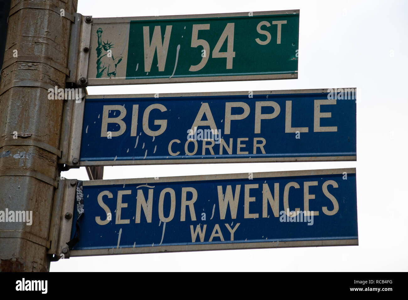 La Ciudad de Nueva York, Estados Unidos - 17 de noviembre 2018: Las señales de la carretera para el West 54th, Big Apple Corner y Senor Wences camino cuelgan de una farola en una Boradway Foto de stock
